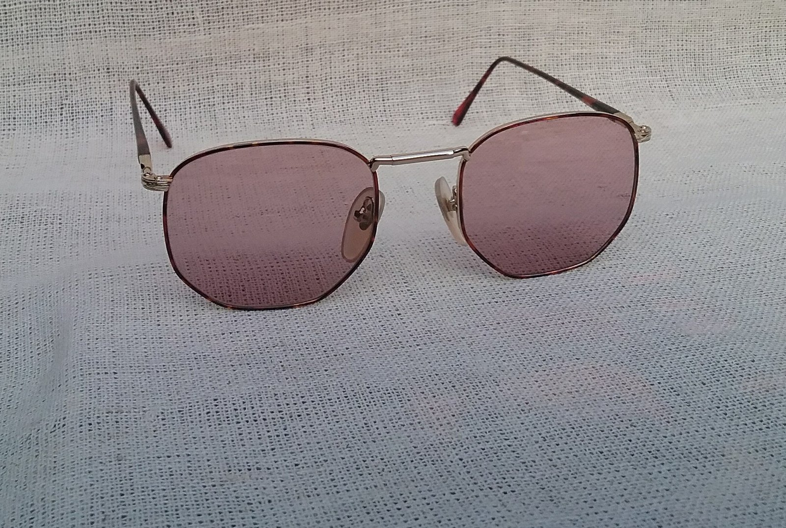 แว่นตาหกเหลี่ยม-อาร์ติสท์ อองวี โดย ลามี่ ผู้ผลิตที่เก่าแก่และดีที่สุดของฝรั่งเศส มือหนึ่ง สต็อกเก่าทศวรรษ1990 กรอบทองขลิบลายกระ เลนส์กระจกคริสตัล หายาก สีกลีบบัว-อเมทิสต์ มองเห็นดวงตาผู้สวมใส่ น้ำหนักเบา 26กรัม ขนาดมาตรฐานโมเดลนี้131mm ไม่เล็ก กำลังใส่สบาย ๆ Vintage EN VUE By LAMY handmade in Japan