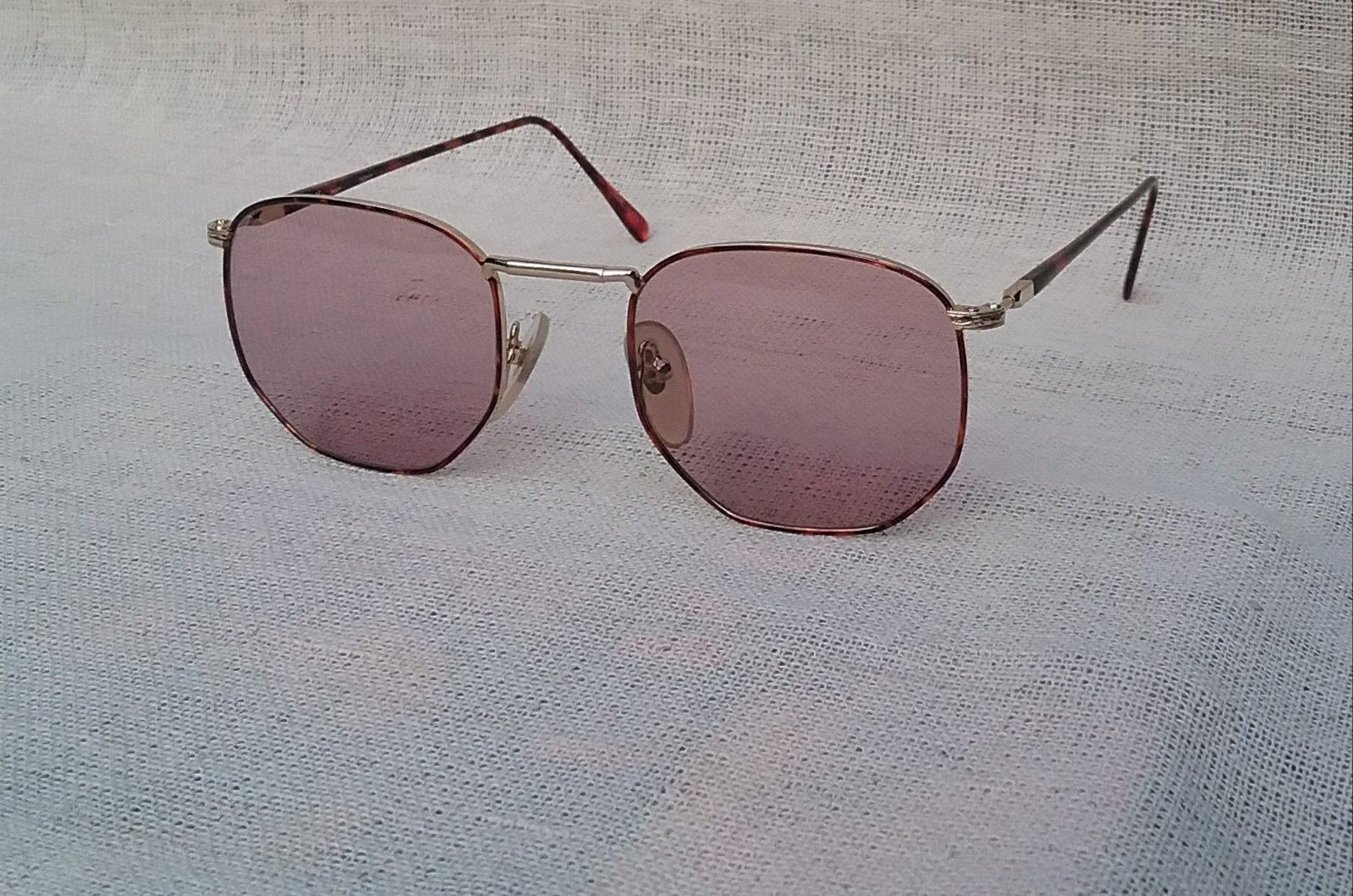 แว่นตาหกเหลี่ยม-อาร์ติสท์ อองวี โดย ลามี่ ผู้ผลิตที่เก่าแก่และดีที่สุดของฝรั่งเศส มือหนึ่ง สต็อกเก่าทศวรรษ1990 กรอบทองขลิบลายกระ เลนส์กระจกคริสตัล หายาก สีกลีบบัว-อเมทิสต์ มองเห็นดวงตาผู้สวมใส่ น้ำหนักเบา 26กรัม ขนาดมาตรฐานโมเดลนี้131mm ไม่เล็ก กำลังใส่สบาย ๆ Vintage EN VUE By LAMY handmade in Japan