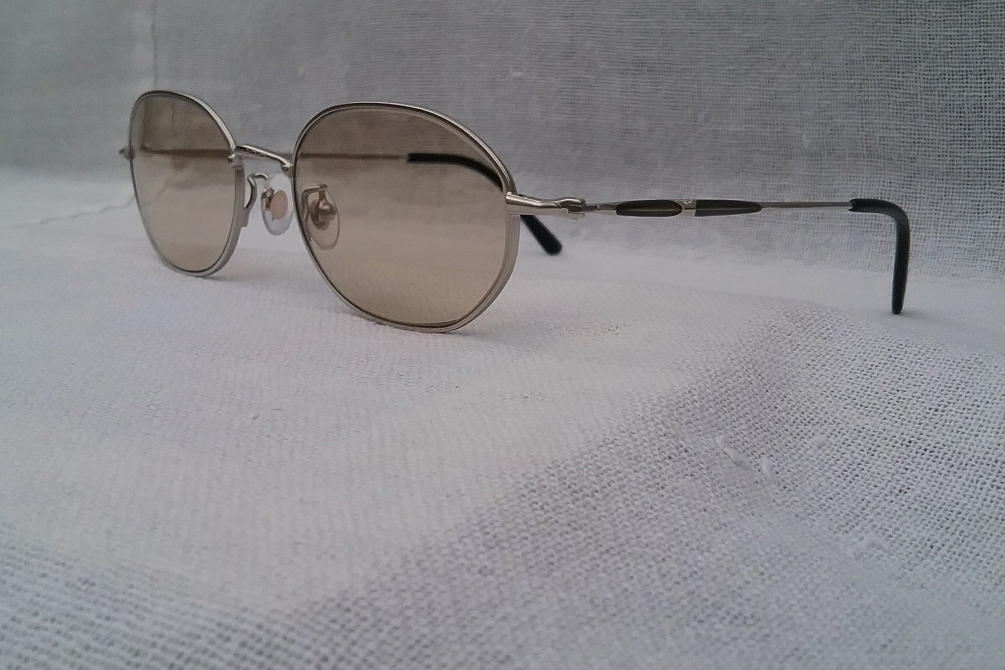 แว่นตาไททาเนียมบริสุทธิ์–ราชสีห์เงิน ทศวรรษ 2000 ผลงานยอดศิลปินนักออกแบบ ทาเคโอะ คิคูจิ ราคานักศึกษา โมเดลคลาสสิค วงรี–จีโอเมตริก เลนส์กระจกคริสตัลกรองแสง หายาก สีน้ำตาล-ชา-สว่าง มองเห็นดวงตาผู้สวมใส่ ขนาดมาตรฐาน 140mm Authentic TAKEO KIKUCHI handmade in Japan