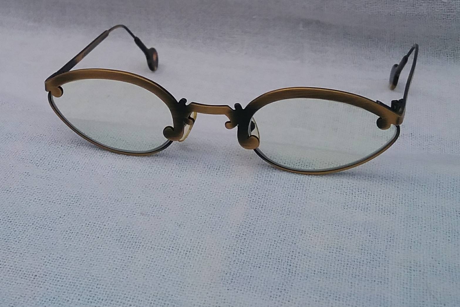 แว่นสายตาอเมริกันสตีมพังก์ แอล เอ อายเวิร์ก ทศวรรษ 1990 ผลงานลิมิเต็ดเอดิชันของช่างฝีมือสายพันธุ์แคลิฟอร์เนียน บาร์บารา แมคเรย์โนลด์ และ เก เกราร์ดี  กรอบงานทองรมดำ โบนัสพิเศษ เลนส์บลูโพรเทคมัลติโค้ท ค่าสายตายาวบวก 175 ป้องกันแสงสีฟ้าที่อันตรายได้สมบูรณ์แบบ Vintage L.A. EYEWORKS handcrafted in Italy