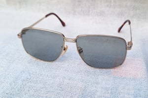 แว่นตาอิตาเลียนทองคำแท้–หุ้ม 12K GF สัดส่วนทองคำบริสุทธิ์ 50% คาซาเด-CASADEI ตัวแท้ ล้ำค่า–หายาก สภาพเทพ เก่าเก็บปลายทศวรรษ 1980 โมเดลคลาสสิก–สี่เหลี่ยม–คานสองชั้น–Double Bridge เลนส์กระจกคริสตัลกันแดด–สีเทาท้องฟ้า–สว่าง มองเห็นดวงตาผู้สวมใส่ ป้องกันรังสี UV100% น.น.37g ขนาดมาตรฐาน 140mm