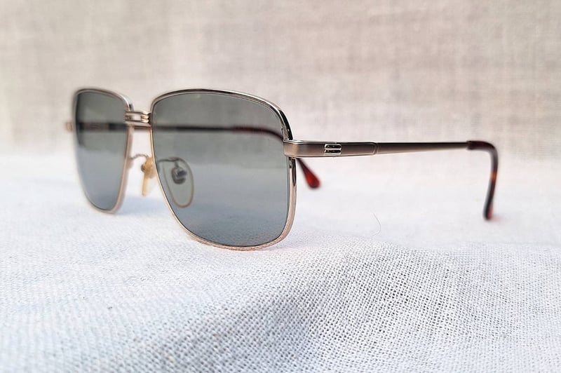 แว่นตาอิตาเลียนทองคำแท้–หุ้ม 12K GF สัดส่วนทองคำบริสุทธิ์ 50% คาซาเด-CASADEI ตัวแท้ ล้ำค่า–หายาก สภาพเทพ เก่าเก็บปลายทศวรรษ 1980 โมเดลคลาสสิก–สี่เหลี่ยม–คานสองชั้น–Double Bridge เลนส์กระจกคริสตัลกันแดด–สีเทาท้องฟ้า–สว่าง มองเห็นดวงตาผู้สวมใส่ ป้องกันรังสี UV100% น.น.37g ขนาดมาตรฐาน 140mm