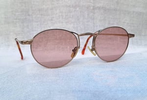 แว่นตาอิตาเลียนอาร์ติสท์–หยดน้ำแพนโต้–จอห์น เลนนอน ในตำนานศตวรรษที่ 20 คาเปลลินี–CAPPELLINI ตัวแท้ สภาพเทพ เก่าเก็บทศวรรษ 1990 กรอบโลหะสีทองเดินลาย เลนส์กระจกคริสตัลฝรั่งเศส หายาก สีกลีบบัว มองเห็นดวงตาผู้สวมใส่ ป้องกัน UV100% น.น.25g ขนาดมาตรฐานโมเดลนี้–Standard One Size137mm สวมใส่ได้ทุกขนาดใบหน้า