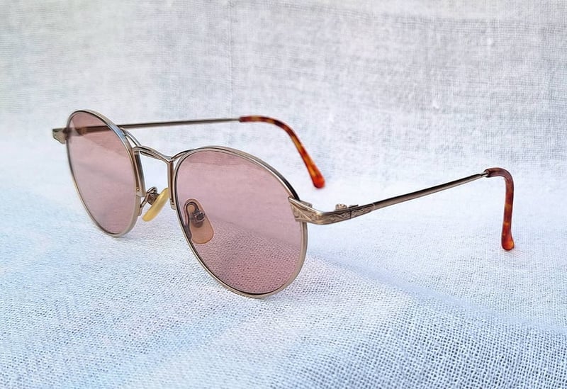 แว่นตาอิตาเลียนอาร์ติสท์–หยดน้ำแพนโต้–จอห์น เลนนอน ในตำนานศตวรรษที่ 20 คาเปลลินี–CAPPELLINI ตัวแท้ สภาพเทพ เก่าเก็บทศวรรษ 1990 กรอบโลหะสีทองเดินลาย เลนส์กระจกคริสตัลฝรั่งเศส หายาก สีกลีบบัว มองเห็นดวงตาผู้สวมใส่ ป้องกัน UV100% น.น.25g ขนาดมาตรฐานโมเดลนี้–Standard One Size137mm สวมใส่ได้ทุกขนาดใบหน้า