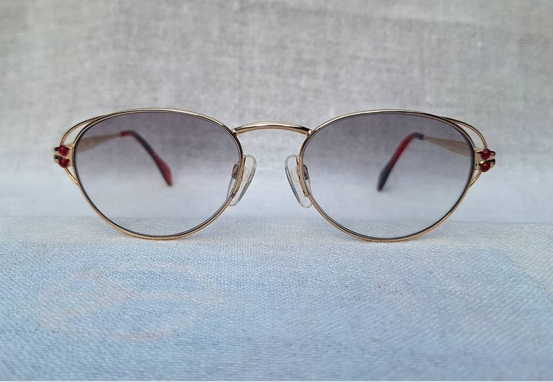 แว่นตาลักซ์ชัวรีแบรนด์สวิสหายากระดับนักสะสม โชปาร์ด–CHOPARD V 6050 กรอบทอง 23KT GP สีน้ำผึ้ง–Honey Gold Frame ประดับอัญมณีทับทิมแท้ 4 เม็ด โอ พระเจ้า.. เลนส์โพลีคาร์บอเนตกันแดด สีเทาท้องฟ้า–ไล่ระดับ มองเห็นดวงตาผู้สวมใส่ ป้องกันรังสี UV 100% ขนาดมาตรฐาน 139mm สวมใส่ได้ทุกขนาดใบหน้า